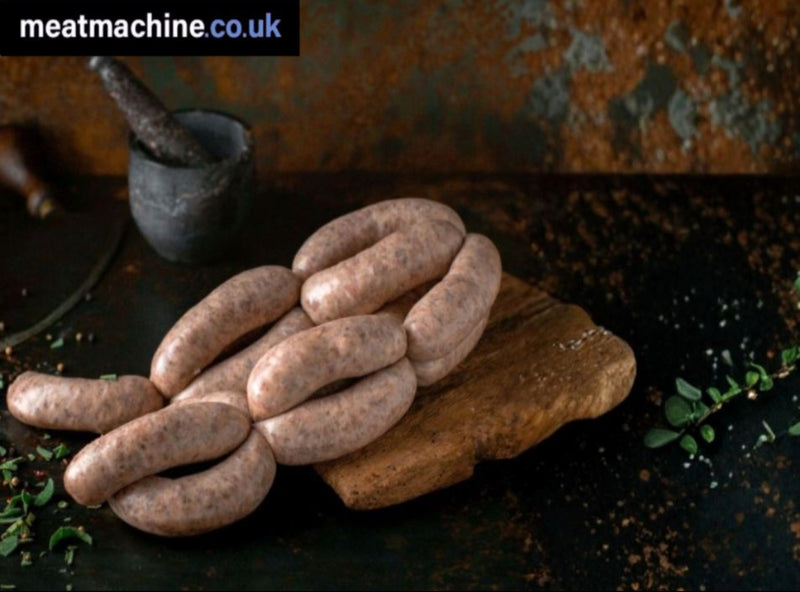 A photo of freshly made Cumberland sausages on a wooden surface, with herbs and spices in the background.