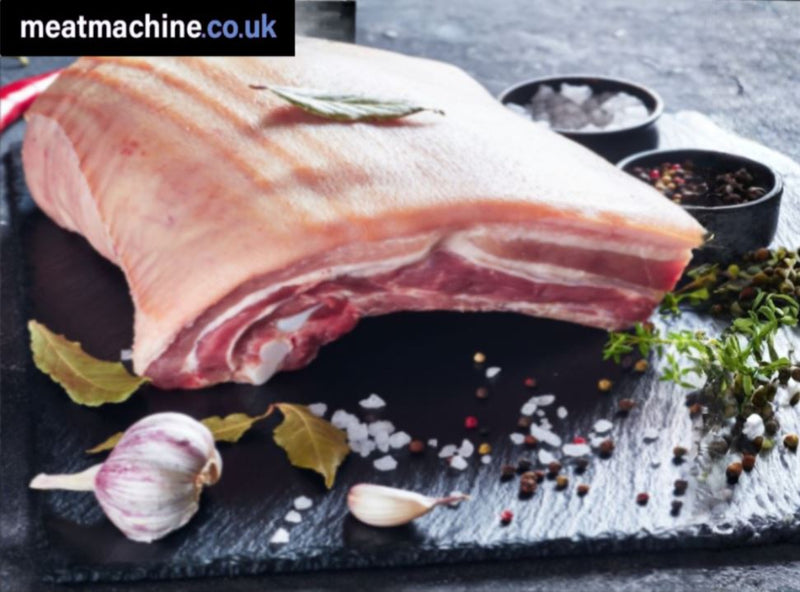 Raw meat on a cutting board with spices and herbs, featuring the brand 'meatmachine.co.uk'.