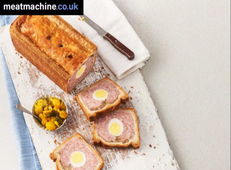 Traditional British Gala Pie sliced to show egg centre, ready for buffet or picnic.
